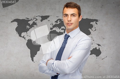 Image of friendly young businessman with crossed arms