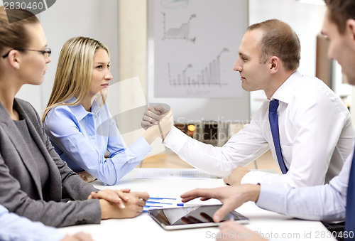 Image of businesswoman and businessman arm wrestling