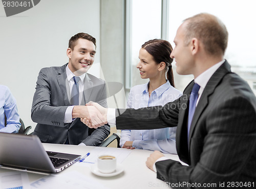 Image of two businessman shaking hands in office