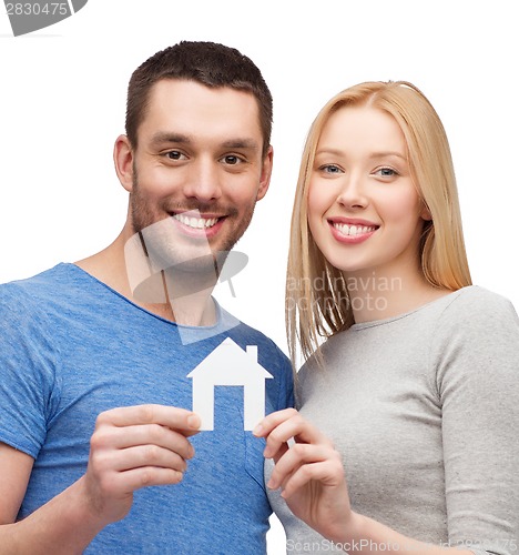 Image of smiling couple holding white paper house