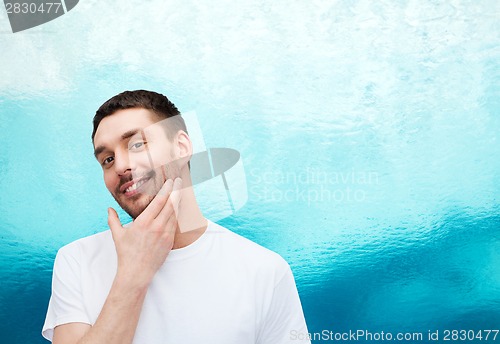 Image of beautiful smiling man touching his face