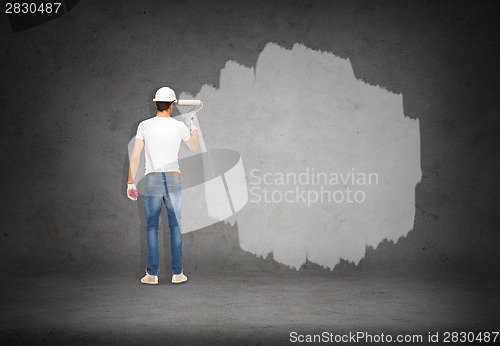 Image of handsome painter in helmet from the back