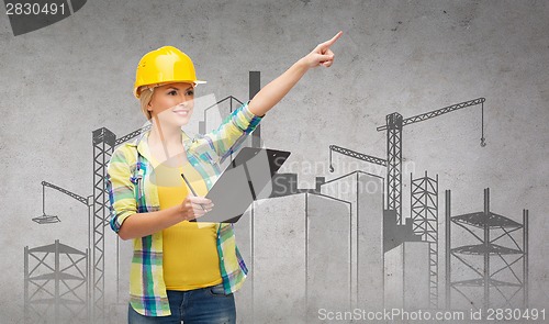 Image of smiling woman in helmet with clipboard