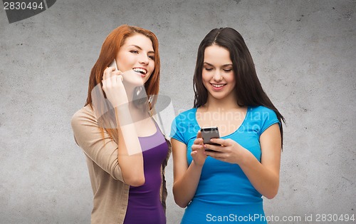 Image of two smiling teenagers with smartphones