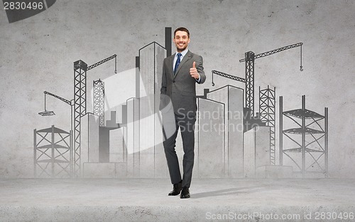 Image of handsome businessman showing thumbs up