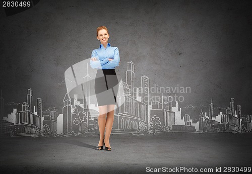 Image of young smiling businesswoman with crossed arms