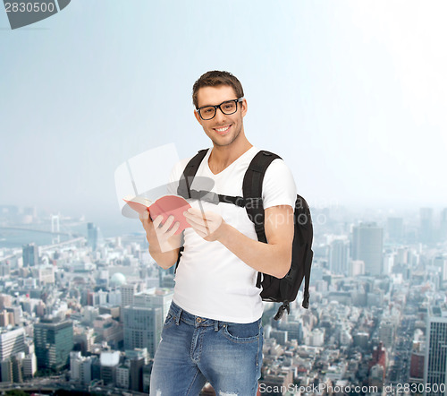 Image of travelling student with backpack and book