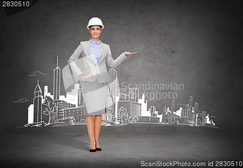 Image of businesswoman in helmet holding something on palm