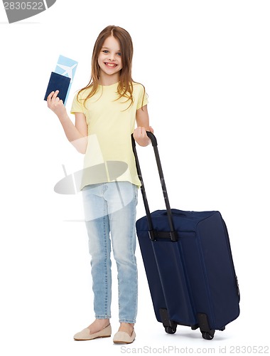 Image of smiling girl with suitcase, ticket and passport