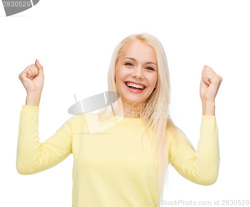 Image of laughing young woman with hands up