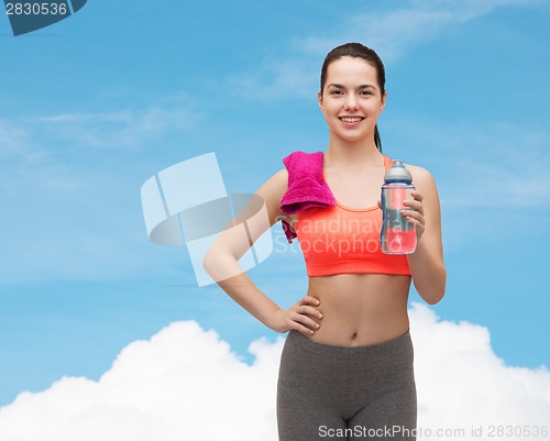 Image of sporty woman with towel and water bottle