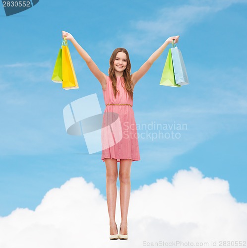 Image of smiling woman in dress with many shopping bags