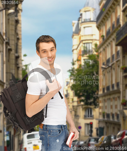 Image of travelling student with backpack and book