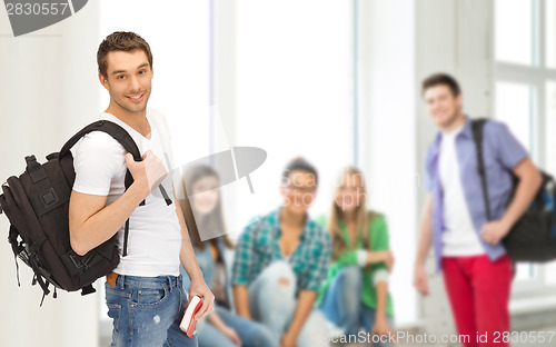 Image of travelling student with backpack and book