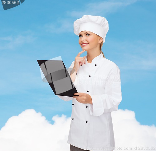 Image of smiling female chef with black blank paper