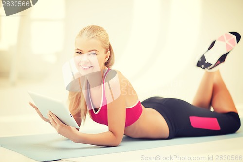 Image of woman lying on the floor with tablet pc