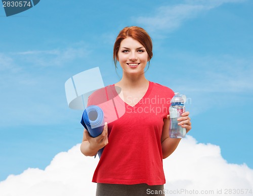 Image of smiling girl with bottle of water after exercising