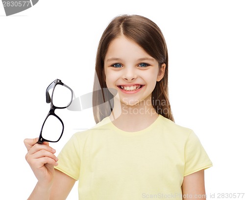 Image of smiling cute little girl holding black eyeglasses