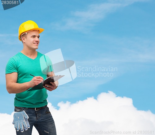 Image of smiling man in helmet with clipboard