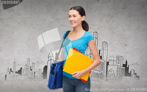 Image of smiling female student with bag and folders