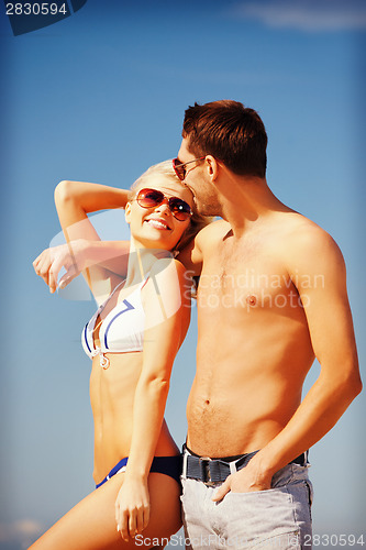 Image of happy couple in sunglasses on the beach