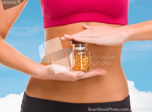 Image of close up of female hands with bottle of capsules