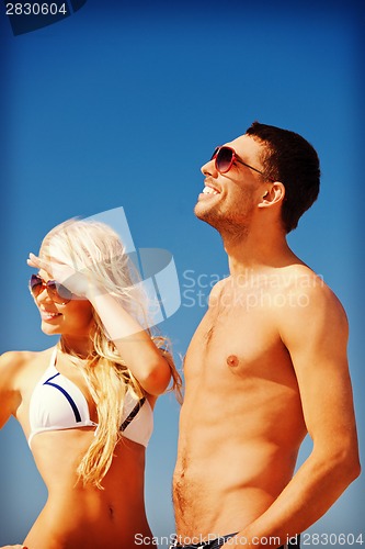 Image of happy couple in sunglasses on the beach