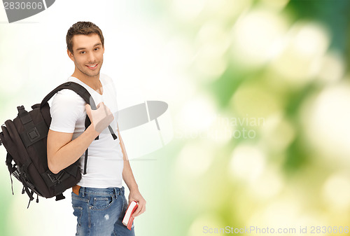 Image of travelling student with backpack and book