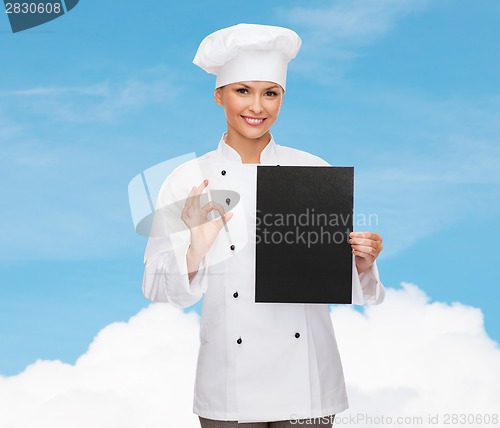 Image of smiling female chef with black blank paper