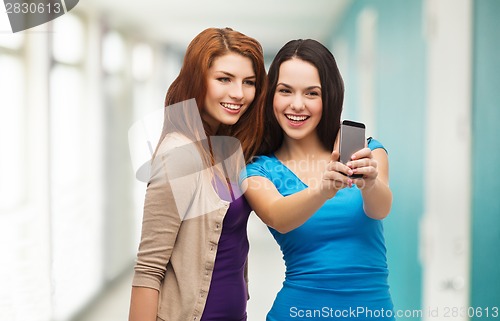 Image of two smiling teenagers with smartphone