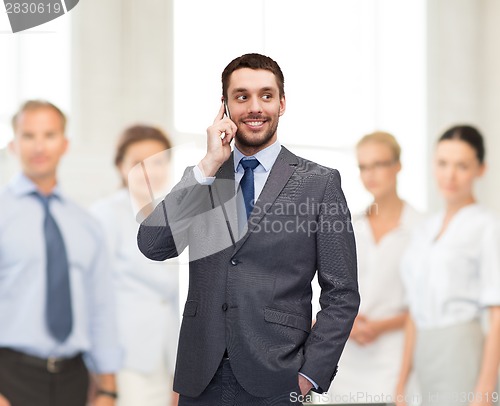 Image of young smiling businessman with smartphone