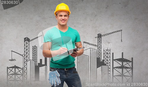 Image of smiling man in helmet with clipboard