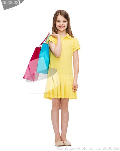 Image of smiling little girl in dress with shopping bags