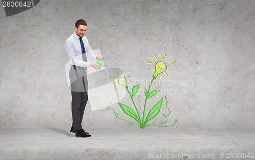 Image of handsome businessman with green watering can