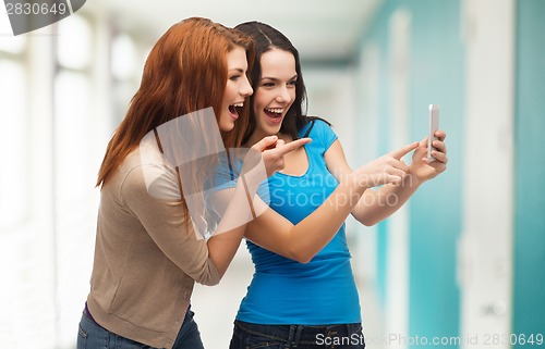 Image of two smiling teenagers with smartphone