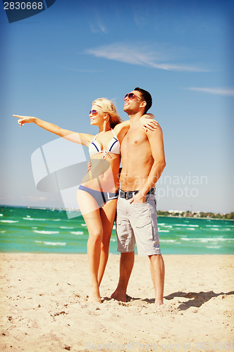 Image of happy couple in sunglasses on the beach