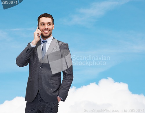 Image of young smiling businessman with smartphone