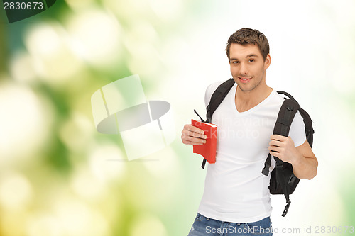 Image of travelling student with backpack and book