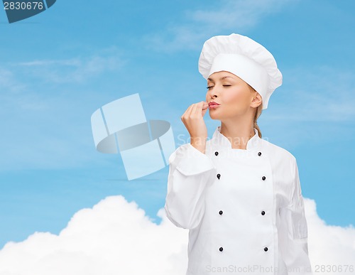 Image of smiling female chef showing delicious sign