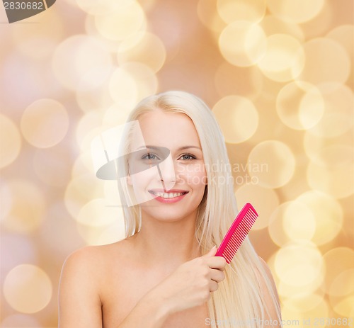 Image of smiling woman with hair brush