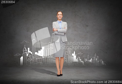 Image of young smiling businesswoman with crossed arms
