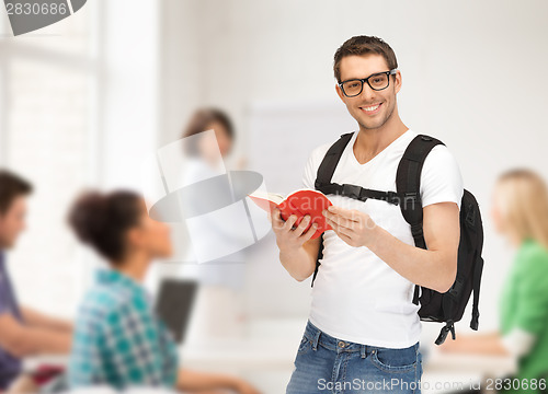 Image of travelling student with backpack and book