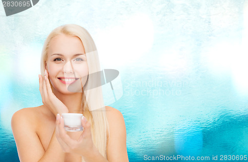 Image of woman applying cream on her skin