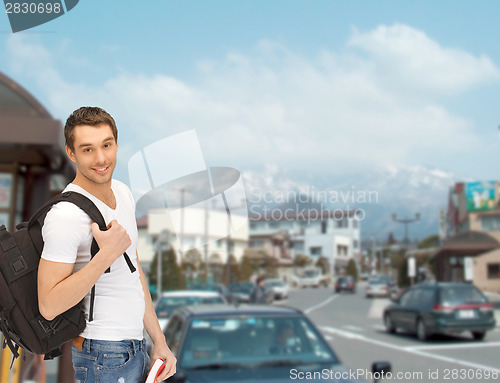 Image of travelling student with backpack and book
