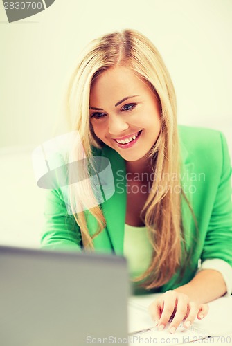 Image of businesswoman with laptop in office