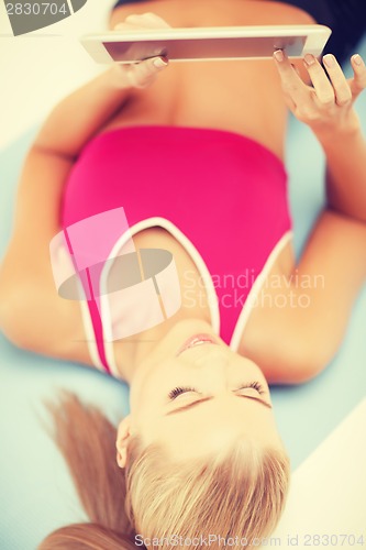 Image of woman lying on the floor with tablet pc