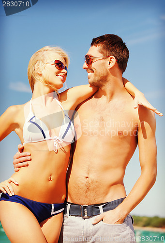 Image of happy couple in sunglasses on the beach