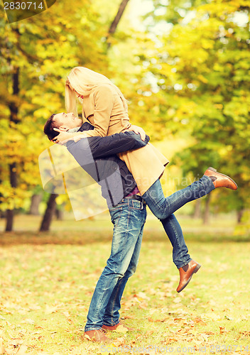 Image of romantic couple playing in the autumn park