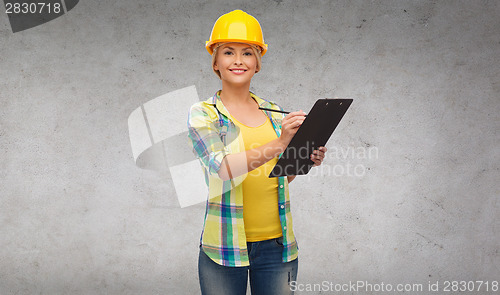 Image of smiling woman in helmet with clipboard