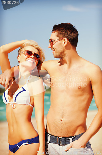 Image of happy couple in sunglasses on the beach